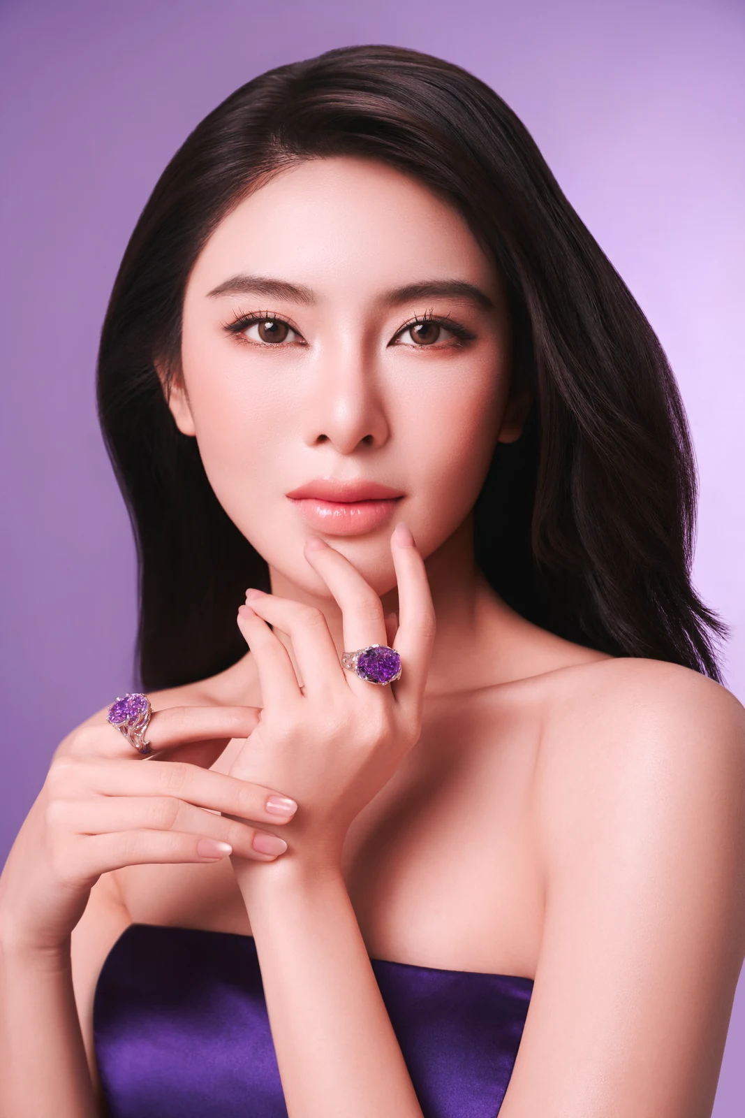 A model wearing purple Chovel jewelry with a violet satin dress